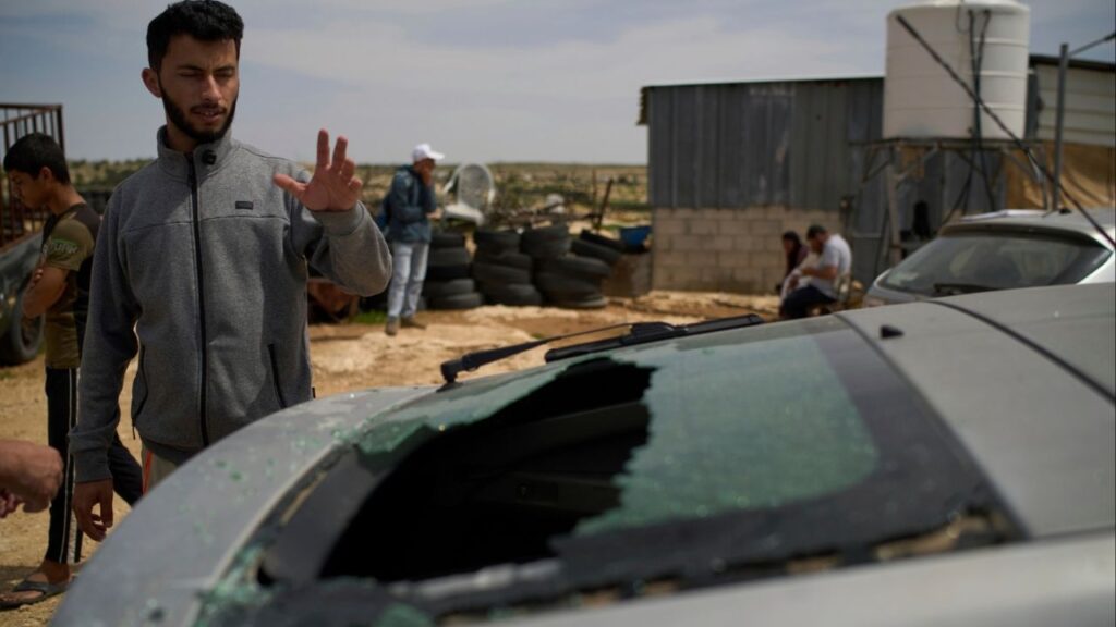 Basel Adra, Palestinian co-director of the Oscar winner documentary "No Other Land", looks at the damaged car of the Palestinian co-director Hamdan Ballal, who was attacked by Jewish settlers before being detained by the Israeli army in the village of Susiya, in Masafer Yatta, south Hebron hills, Tuesday, March 25, 2025. (AP/Leo Correa)